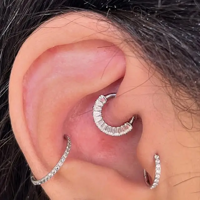 Orelha com argola de pedras no daith e duas argolas finas com pedras