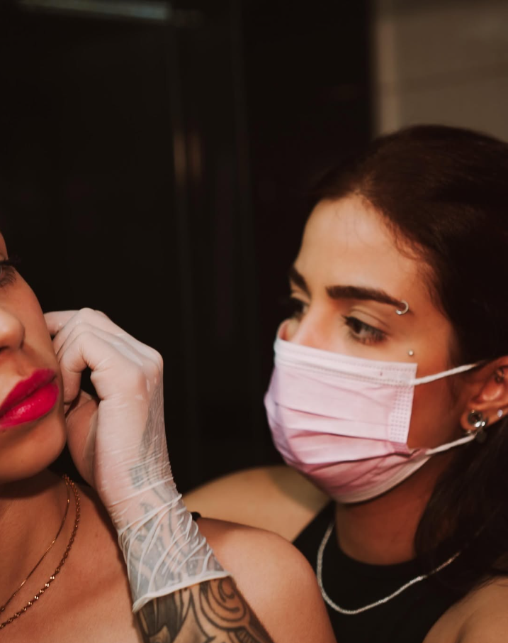 Profissional aplicando piercing em cliente