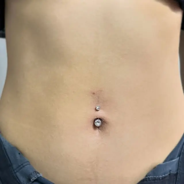 Umbigo com piercing de duas pedras claras